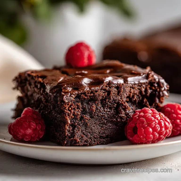Elegant squares of deep brown fudge, arranged on a white plate with a dusting of cocoa powder, hinting at the decadent treat.