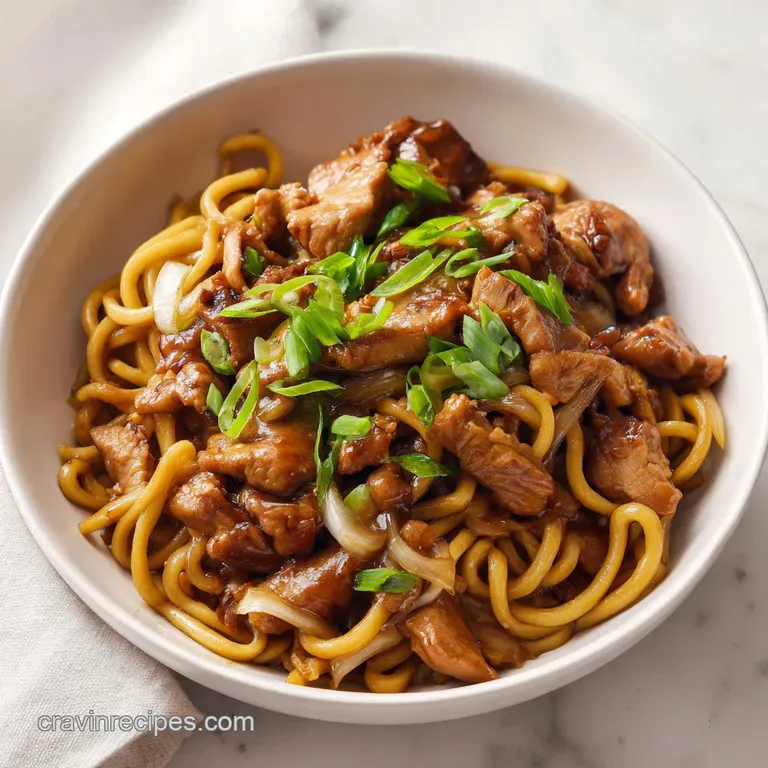 A ceramic bowl of glossy noodles and glazed chicken topped with toasted sesame seeds and fresh sliced scallions.